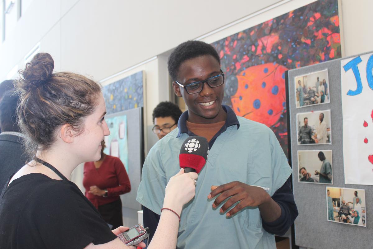 Rayan Primus from John Grant High School discusses his wound project with a CBC reporter. 