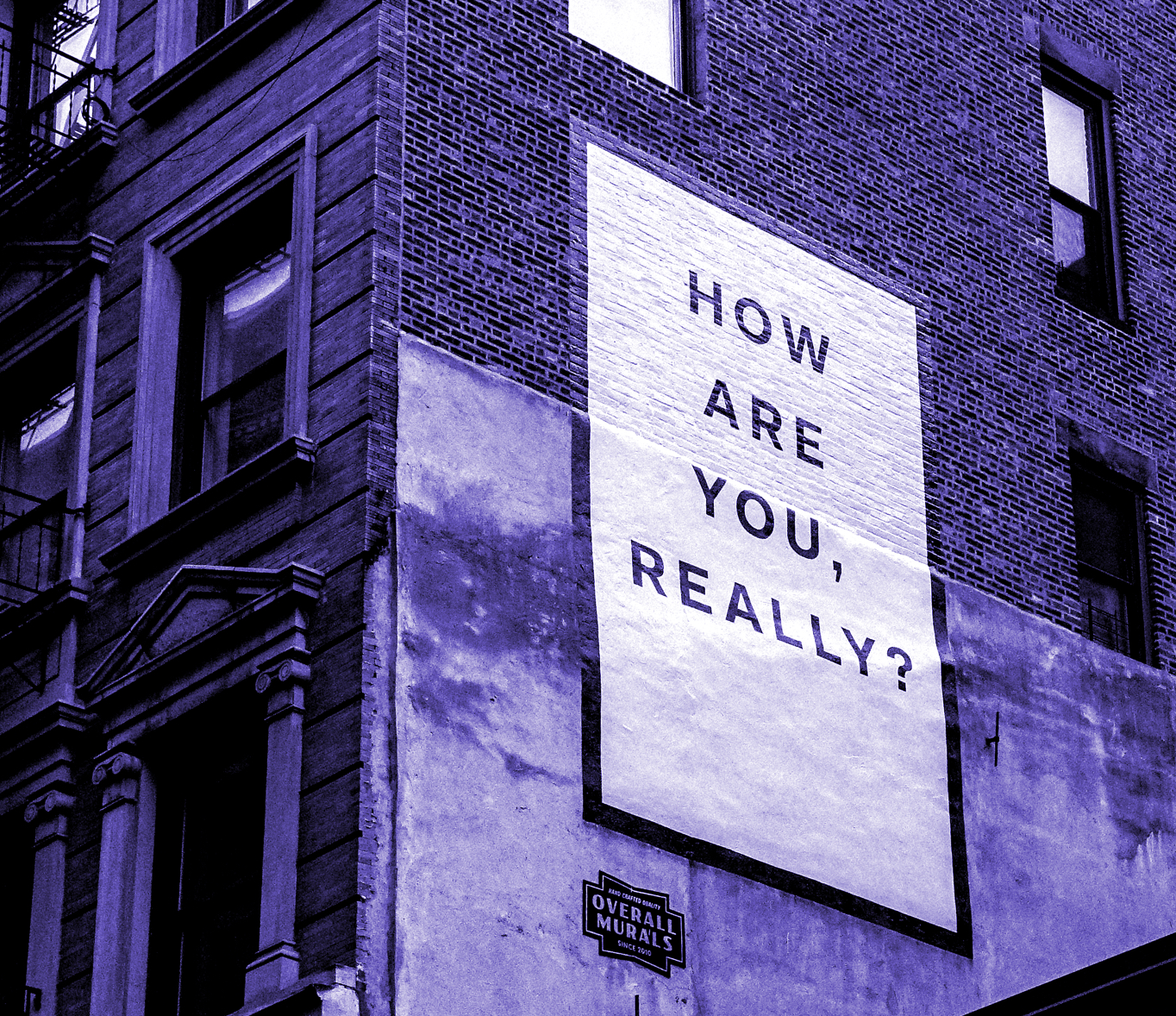 Building walls with a mural reading "How are you, really?"