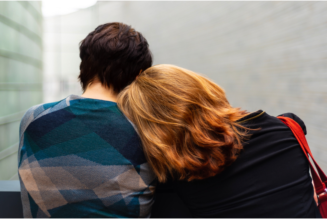 A woman lean on a friend's shoulder